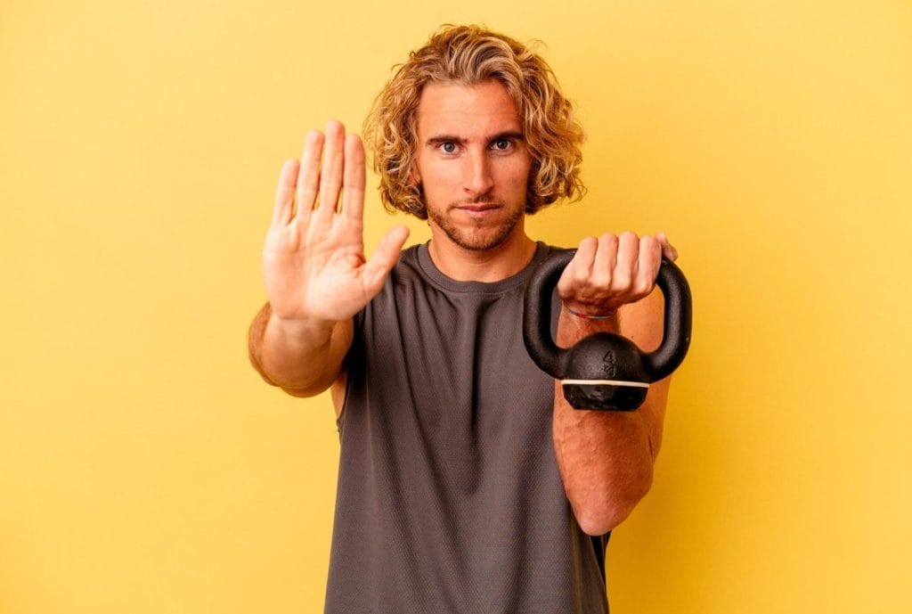 221326 man holding a kettle bell - home workout