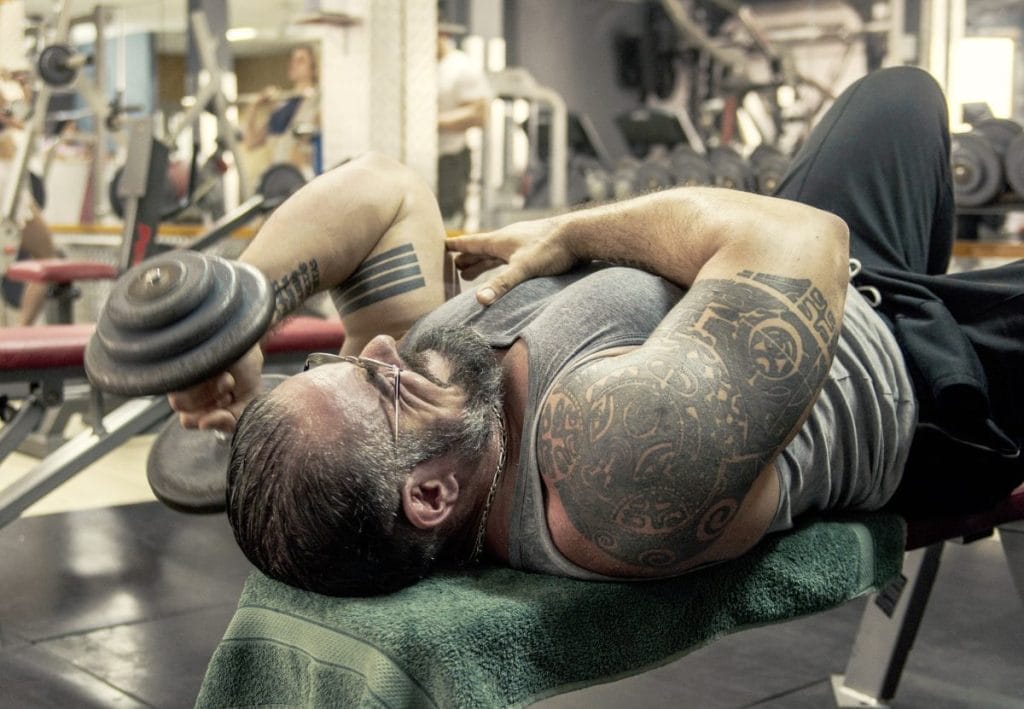 man doing skull crushers - home dumbbell workout for upper body