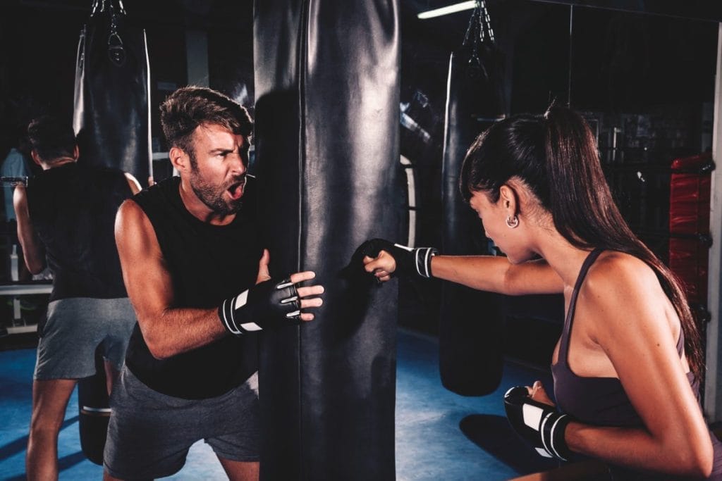 woman punching a bag - At-home Kickboxing Workout with a Bag