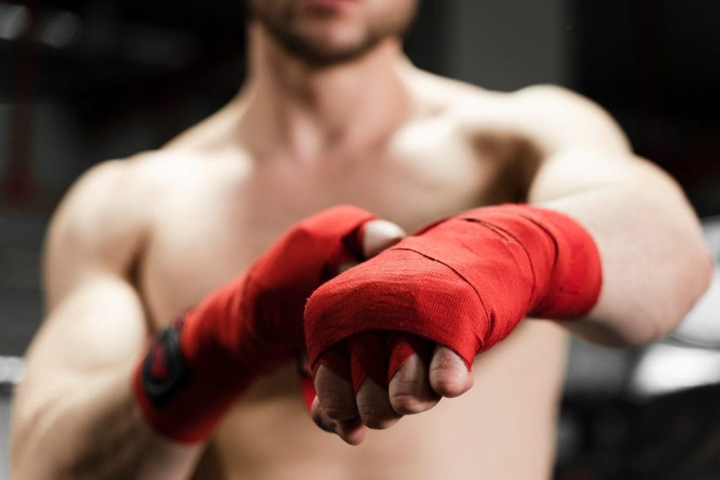 man wearing wrist tapes - At-home Kickboxing Workout with Bag