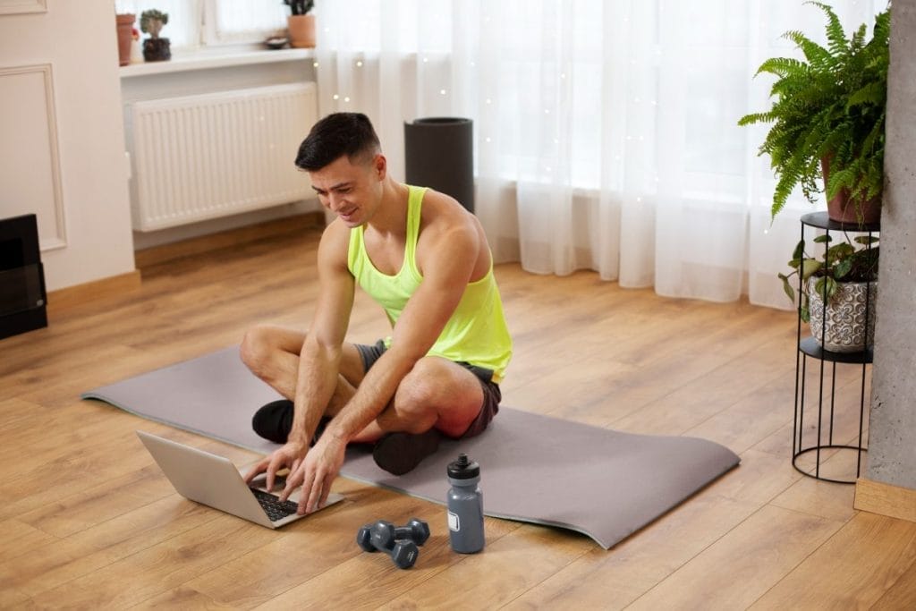 man sitting on a workout mat - home pull workout