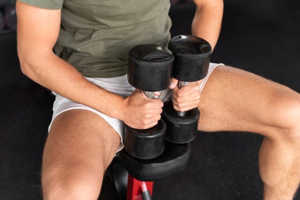 man holding dumbells - At Home Chest Shoulder Triceps Workout