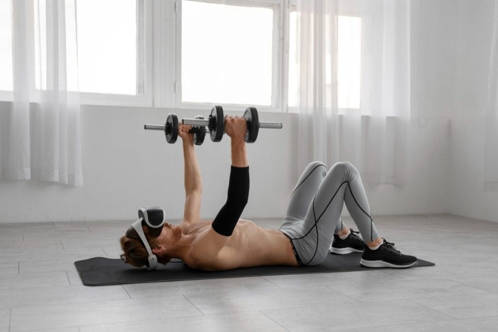 man using dumbells - Chest and Shoulder Workouts to Do at Home