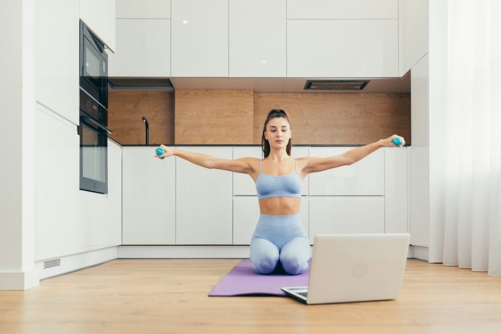 woman using dumbells - Chest and Shoulder Workouts to Do at Home 
