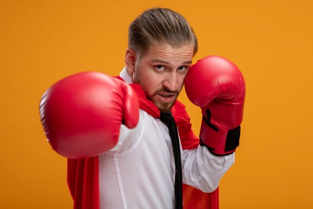man wearing boxing gloves - At-home Kickboxing Workout with a Bag